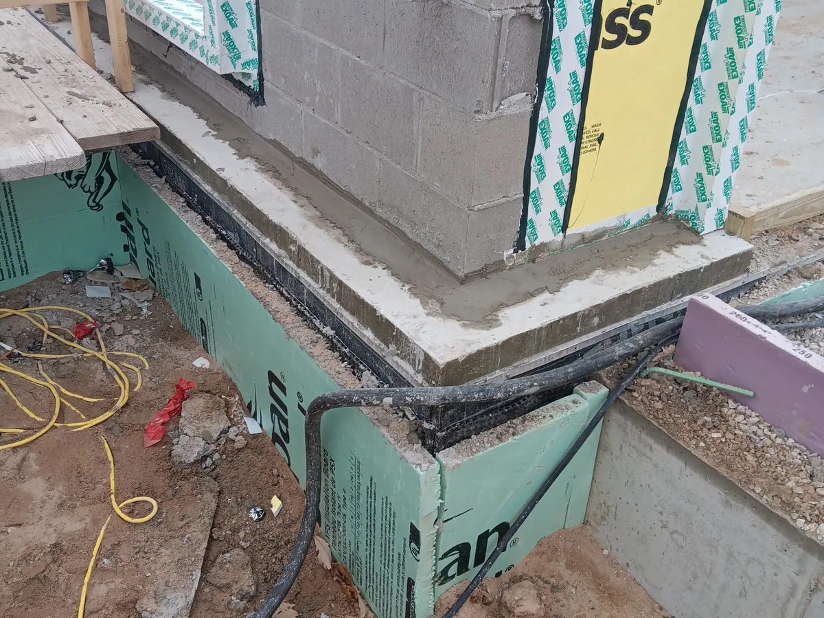 Close up of air barrier detailing at the corner where the wall meets the foundation