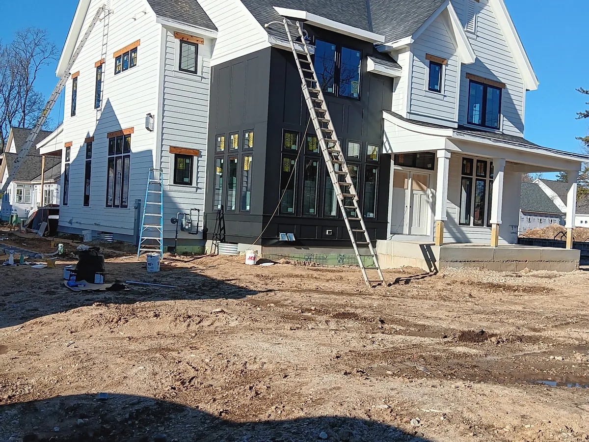 Newly built homes with ladders set up along the front elevation