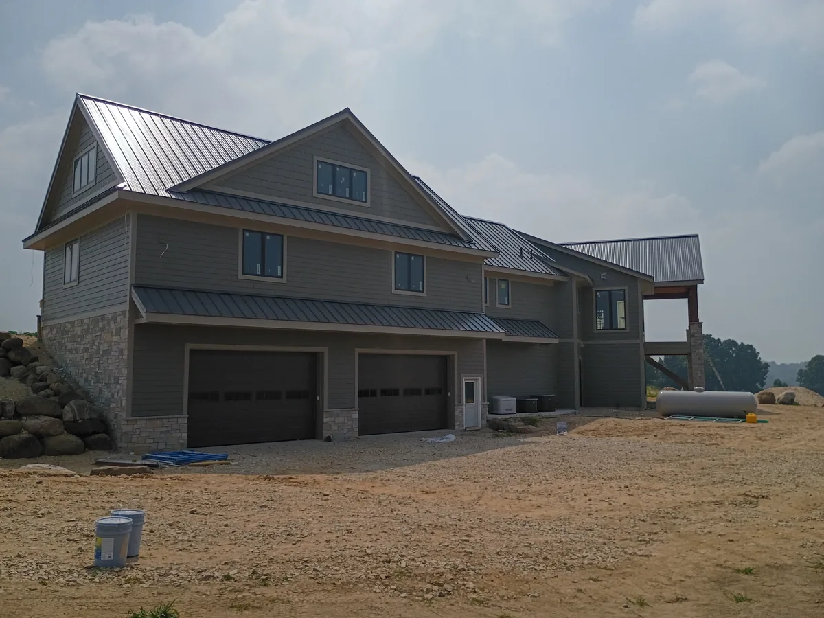 New home exterior with a metal roof and a three car garage