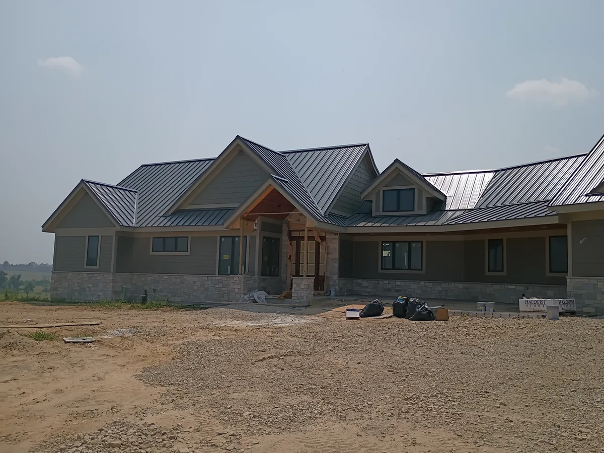 Newly built home with a metal roof and gray exterior